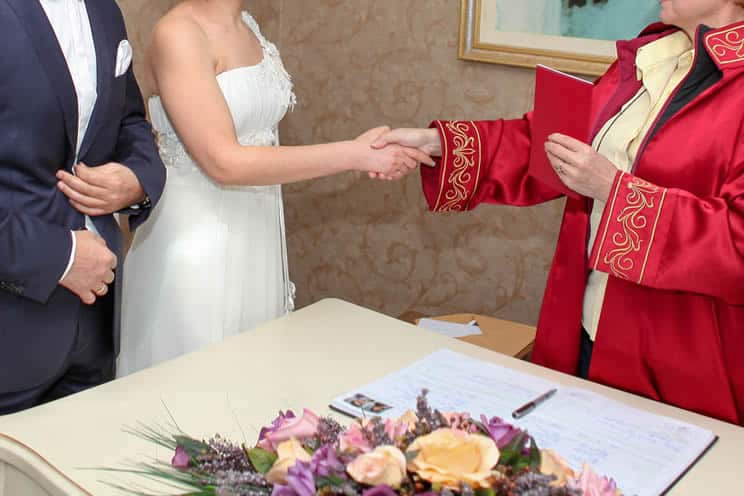 Wedding registrar shaking brides hand after successfully completing civil wedding ceremony