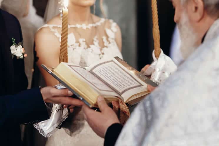 Catholic priest reading from the bible during wedding ceremony