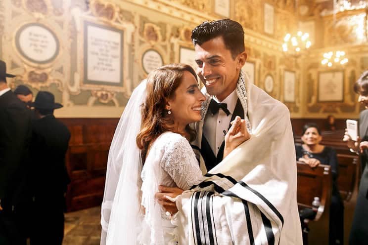 Jewish bride crying whilst she hugs the groom