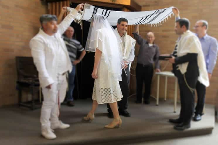 Jewish couple walking under the chuppah during their wedding ceremony