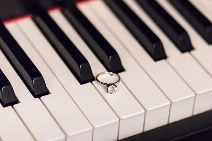 Piano keyboard with a wedding ring on one of the keys