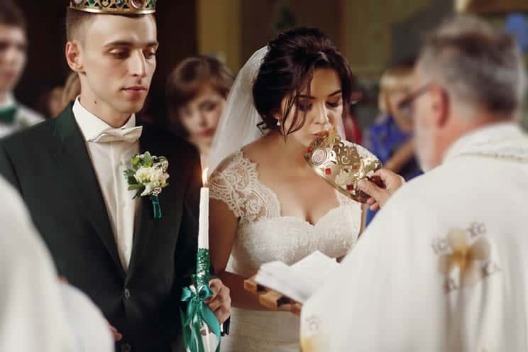 Orthodox bride kissing a crown during Orthodox wedding ceremony