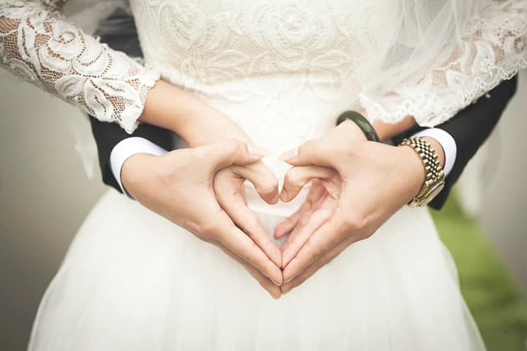 Couple using their hands to make heart symbol